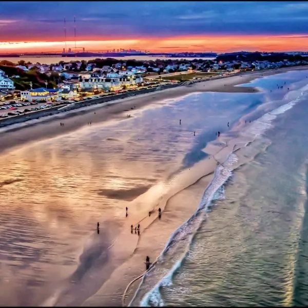 Aerial view of Nantasket Beach in Hull, Massachusetts at sunset with the Boston skyline on the horizon